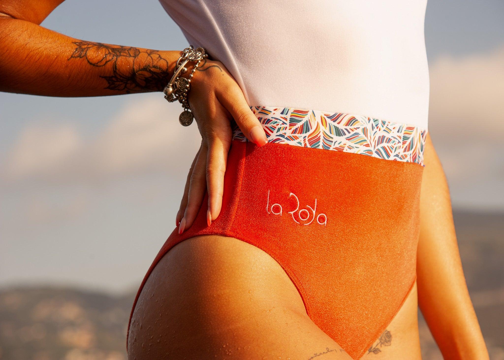 Détail maillot de natation performance orange et blanc 1 pièce la roda